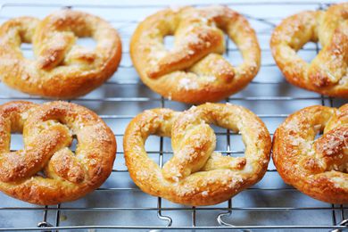 Six Philly soft pretzels cooling on a cooling rack