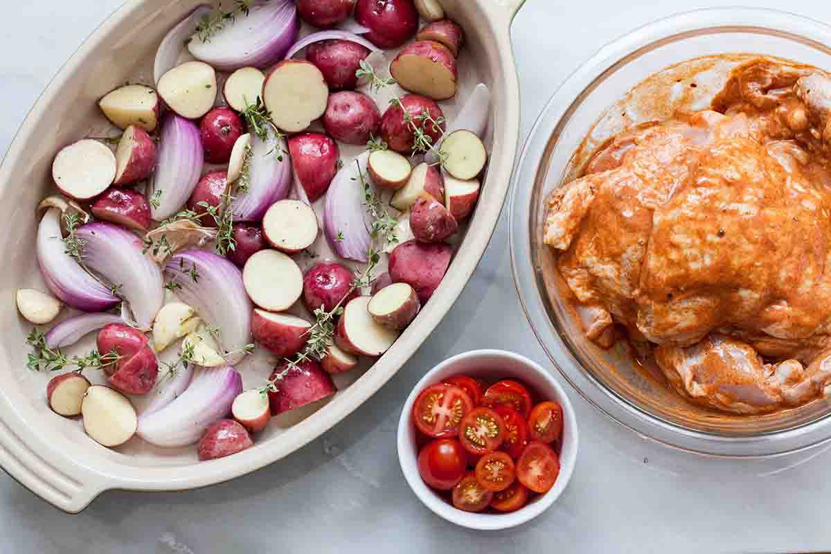 Layer the potatoes and onions for paprika chicken in a baking dish