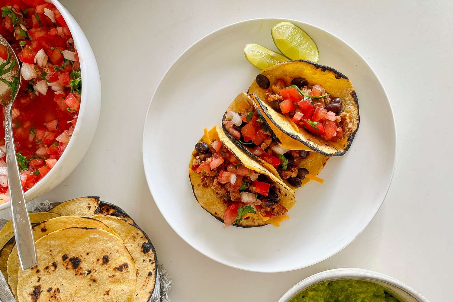 5-ingredient ground chicken tacos on a white plate topped with pice de gallo