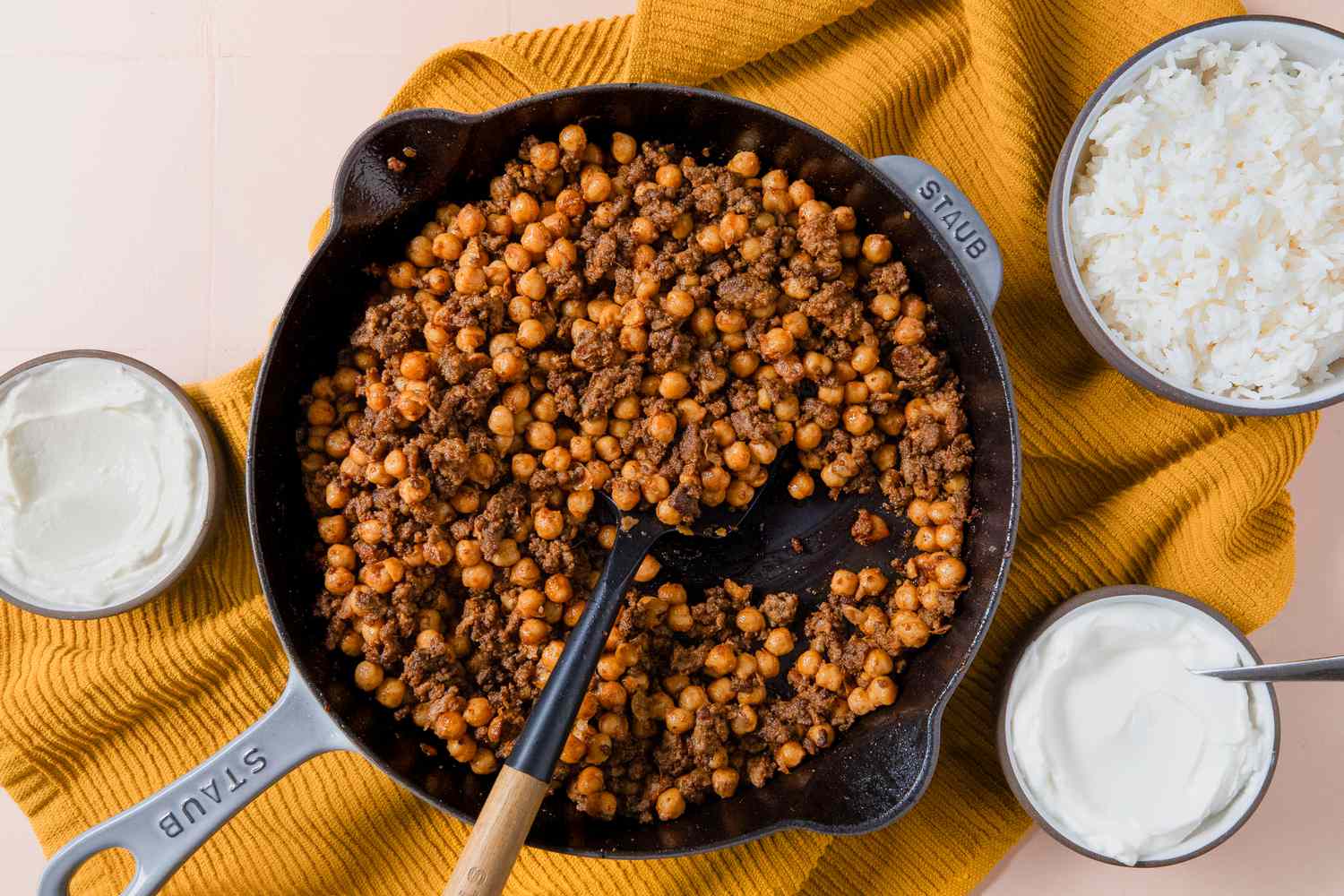 overhead view of 20-Minute One-Pan Beef and Chickpeas in a skillet with a side of greek yogurt and rice