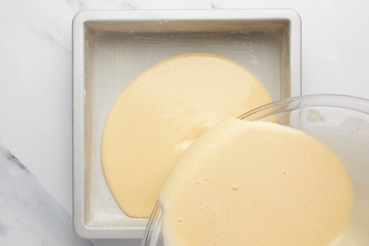 Lazy daisy cake batter poured into the buttered square baking pan 
