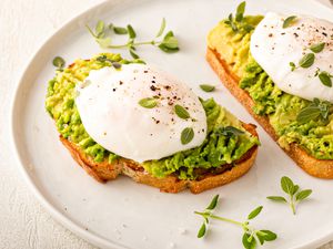 Avocado toast with a perfect poached egg on top with salt and pepper