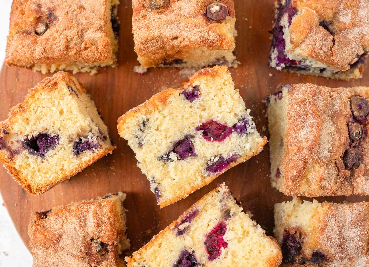 Overhead view of multiple blueberry coffee cake slices on a wooden cutting board