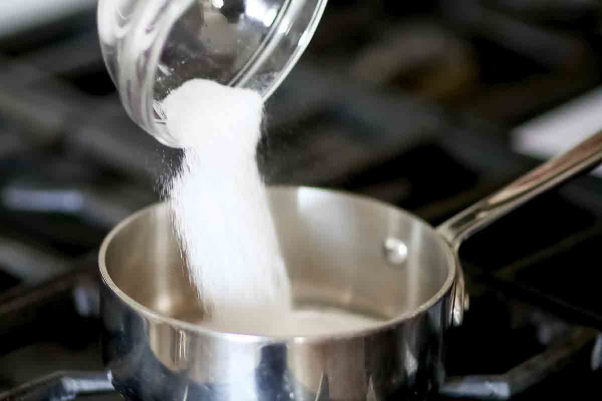 Sugar being poured into a pan
