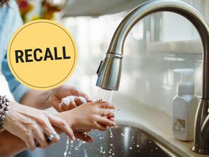 Hands being washed under a faucet with a 'Recall' label displayed