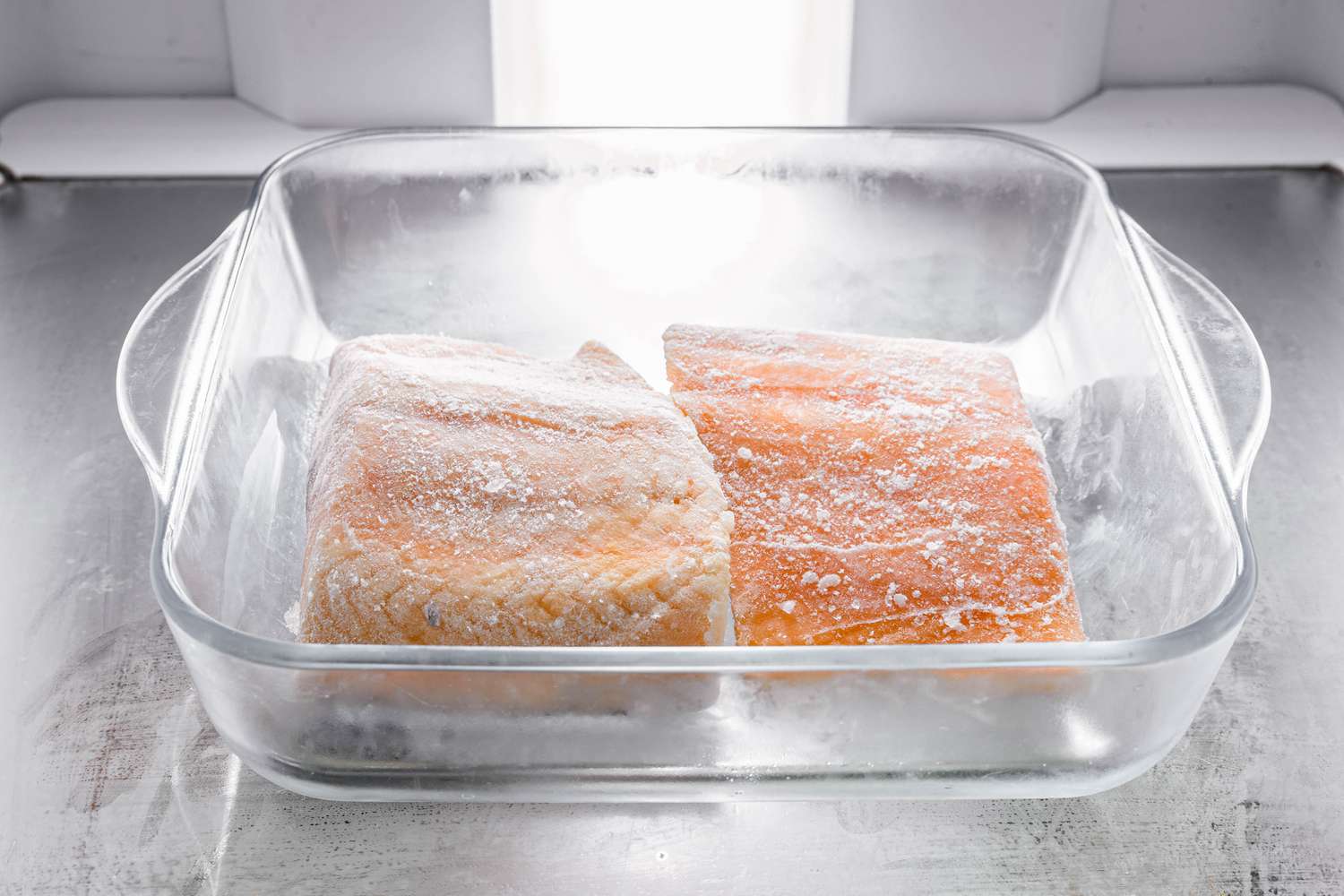 Frozen salmon fillets in a glass Pyrex casserole dish in the refridgerator