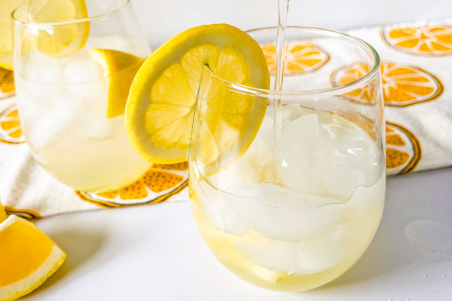 Pouring club soda into a Trader Joe's lemon gin cocktail