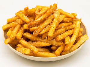 Side view of a bowl with a pile of crispy French fries