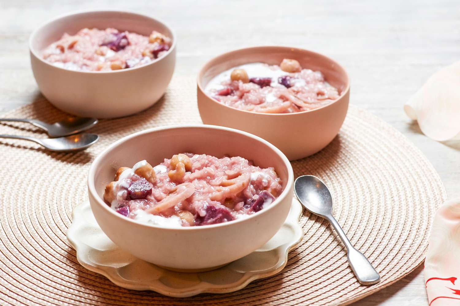 Two bowls of Vietnamese coconut rice pudding served with spoons.