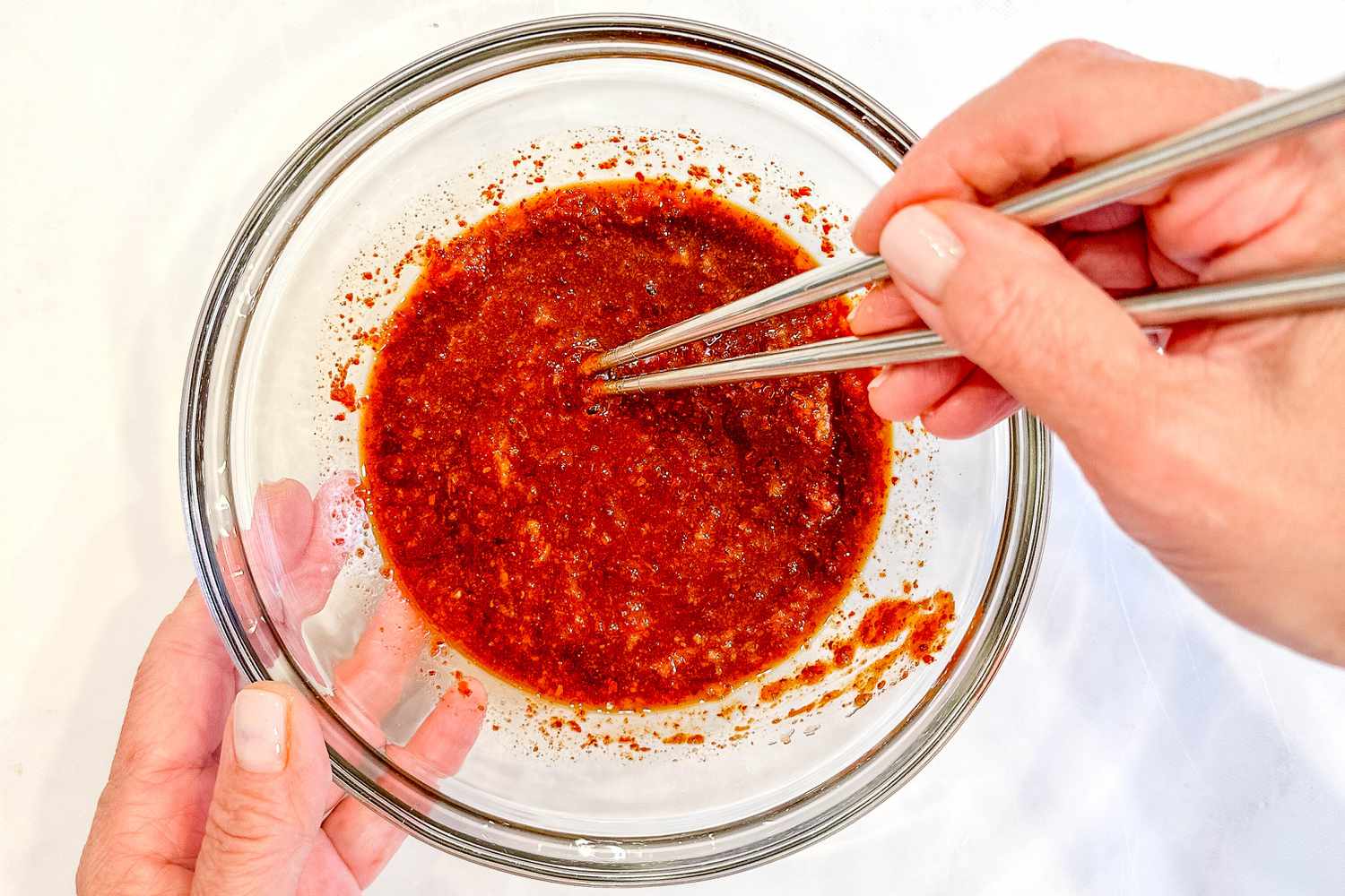 Budae jjigae sauce in a bowl with a pair of chopsticks for Korean army base stew recipe