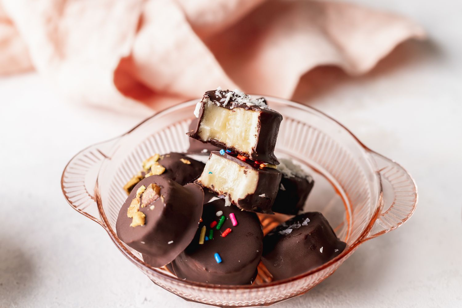 Frozen Chocolate Covered Bananas in a Bowl with the Top Piece Bitten Into