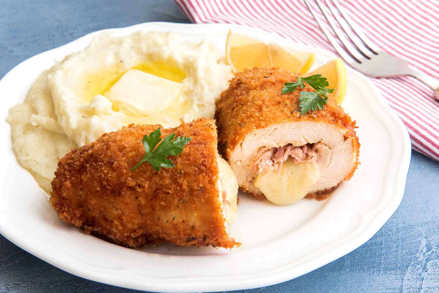 Classic Chicken Cordon Bleu on a plate with mashed potatoes and butter