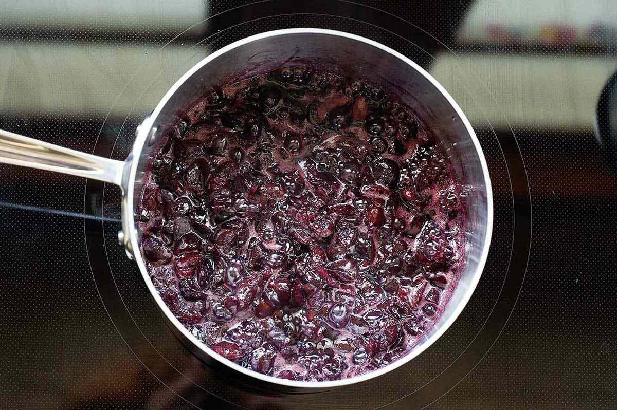 Cherries cooking on the stove to show how to make Black Forest Cake
