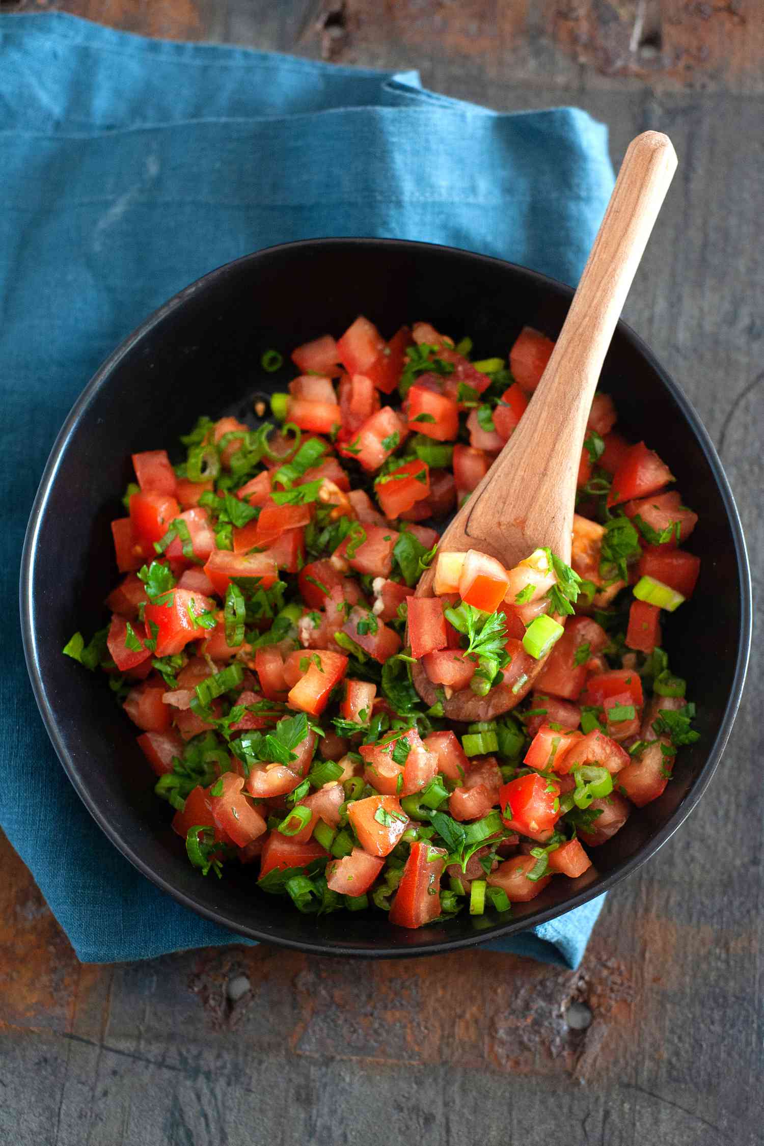 ‘In Bibi’s Kitchen’ Lasary Legioma Recipe in a dark bowl with a wooden spoon.