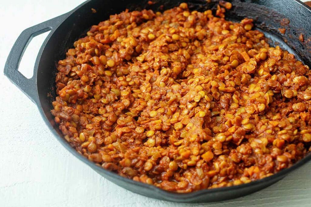Cook lentils and tomatoes in a cast iron skillet for vegan vegetarian sloppy joes