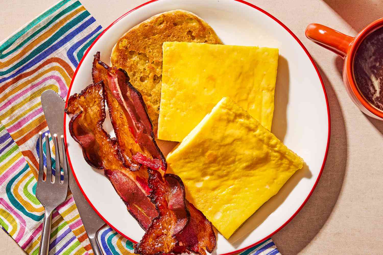 Two slices of baked egg, two slices of bacon and a piece of toast on a plate