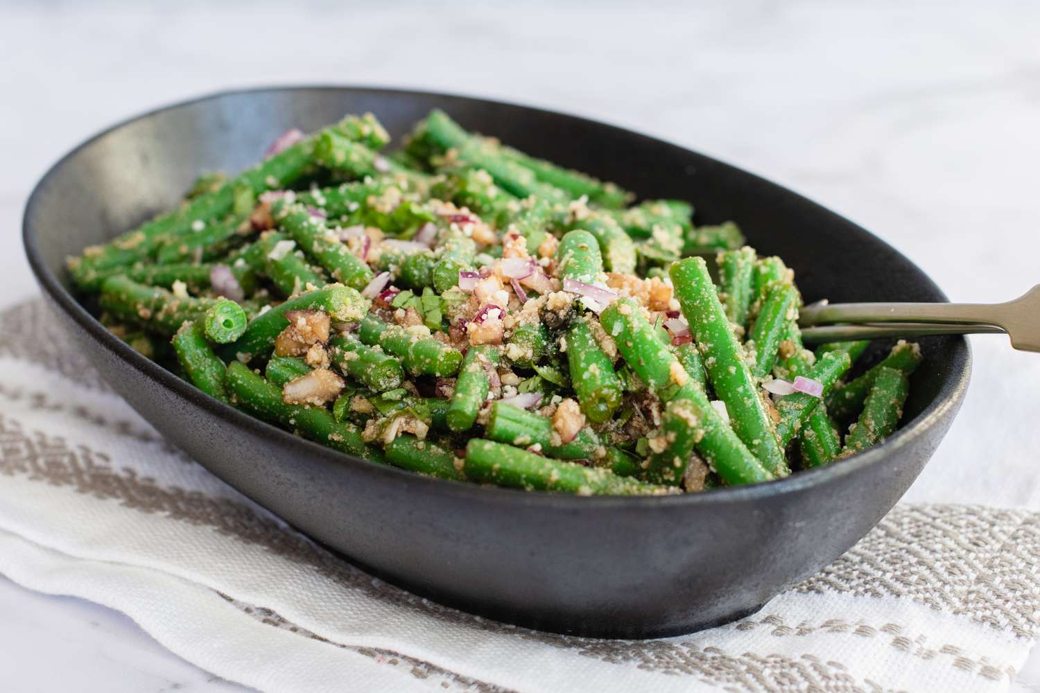 Side view of green bean salad in a serving bowl.