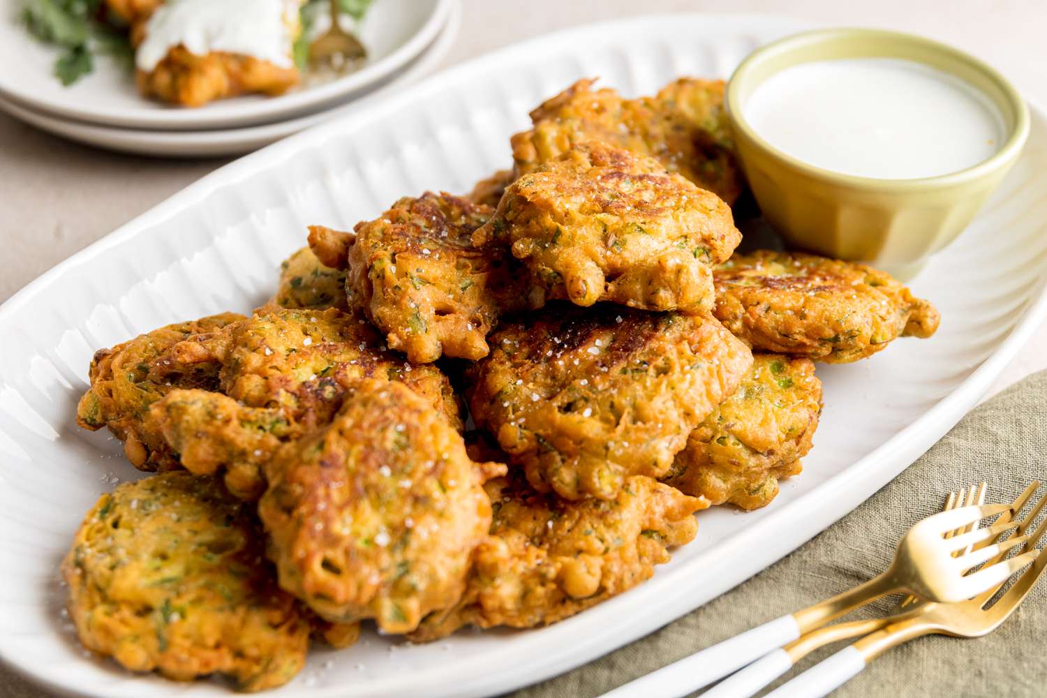 Asparagus pakoras on a white platter.
