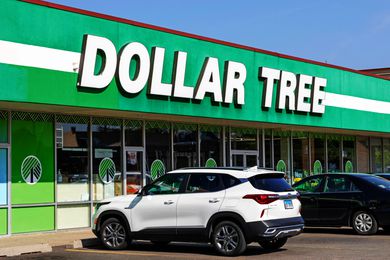 Exterior of a Dollar Tree retail store with parked vehicles in front, showing the store's signage prominently