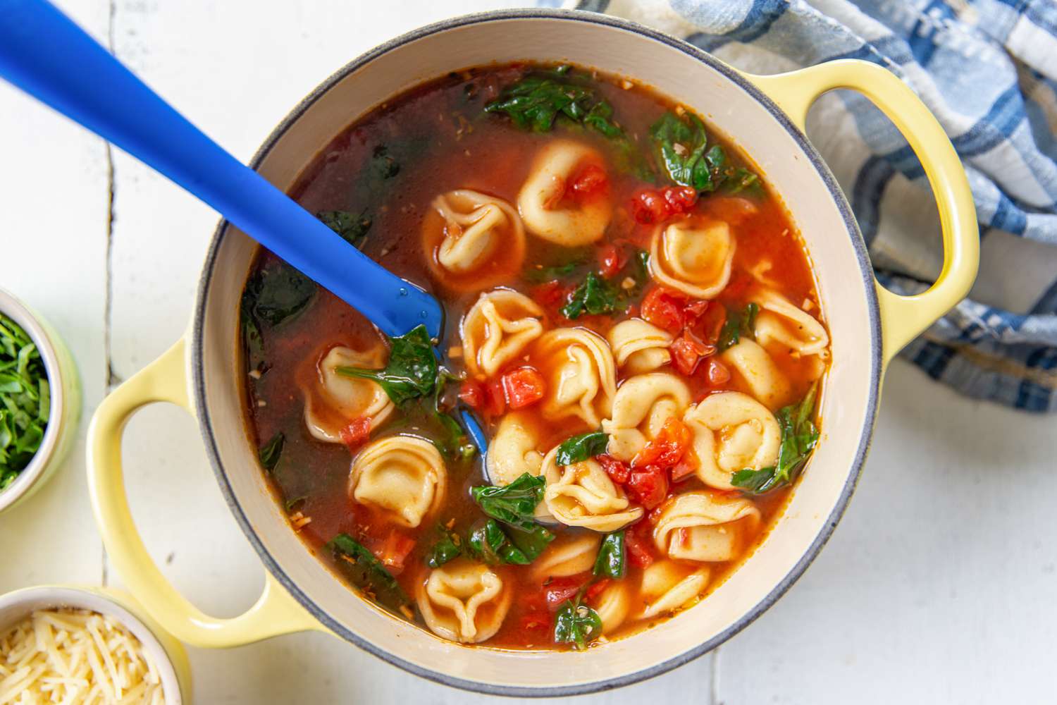 A pot with tortellini soup in a tomato based broth
