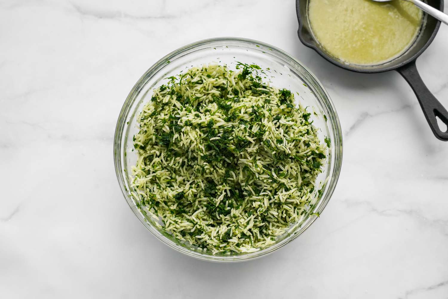 Herbed Rice in a Bowl Next to Garlic Ghee Mixture in a Small Cast Iron Skillet for Sabzi Polo (Persian Herb Rice) Recipe