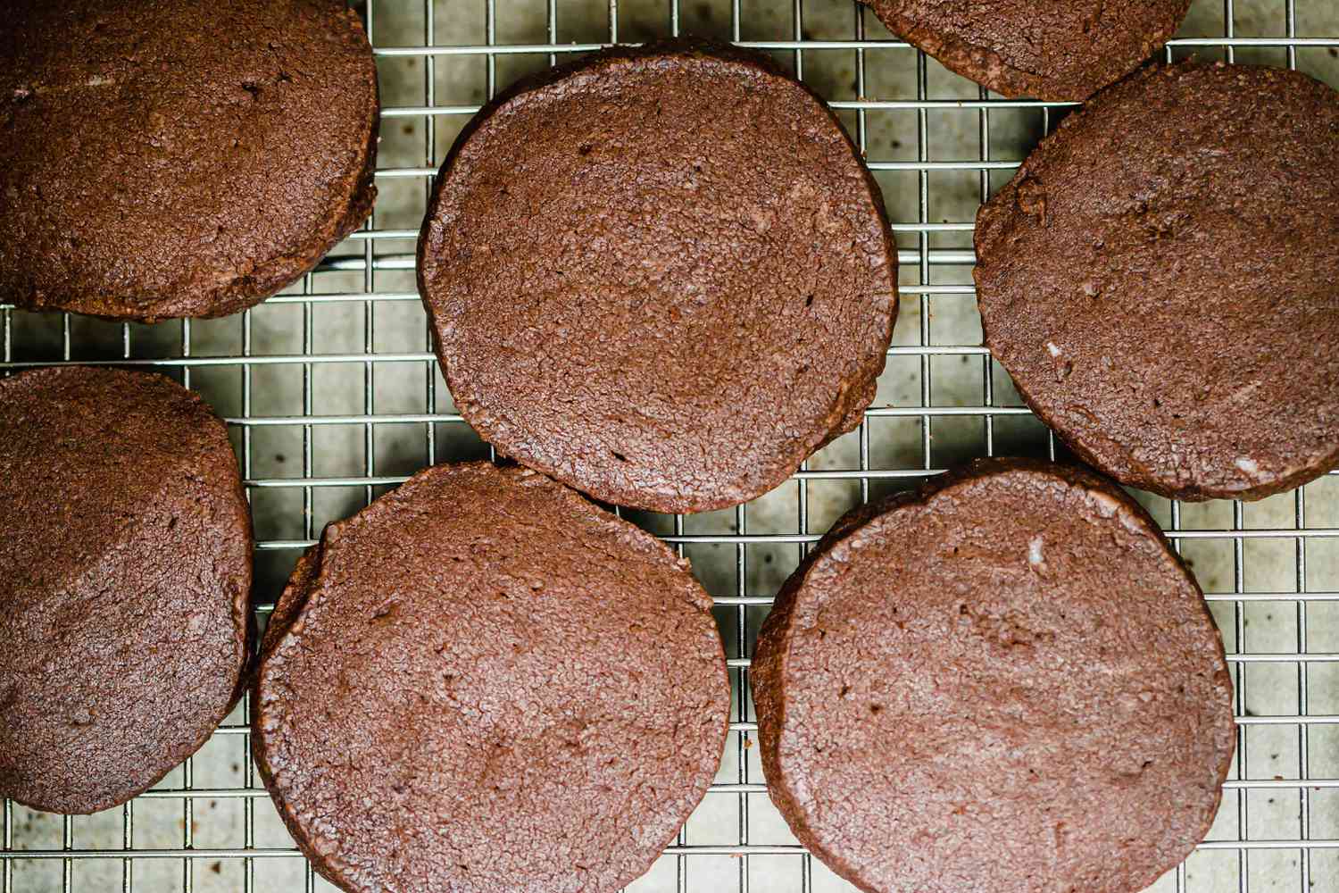 Overhead view of chocolate shortbread cooling on a rack.
