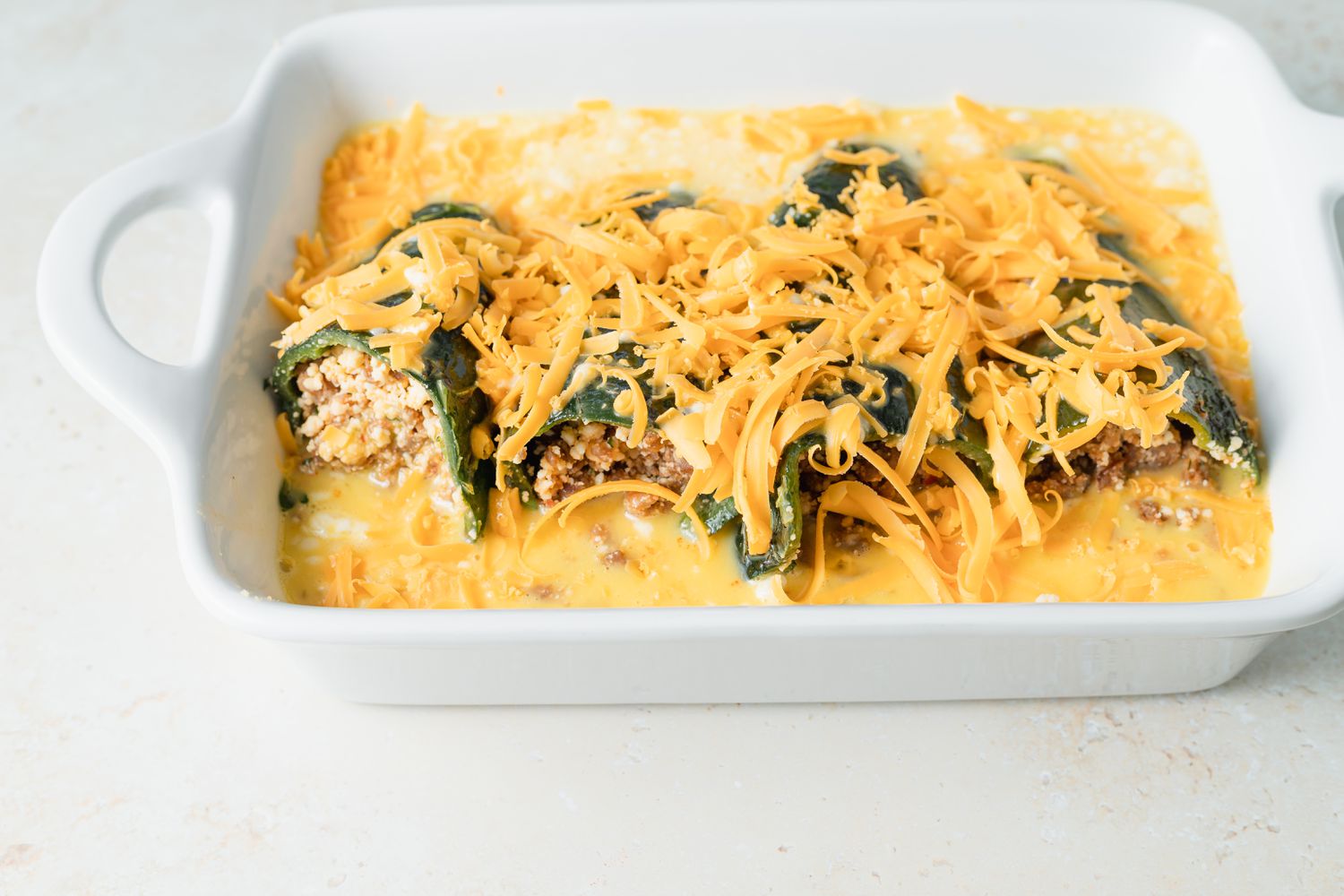 Side view of an unbaked chili relleno casserole.