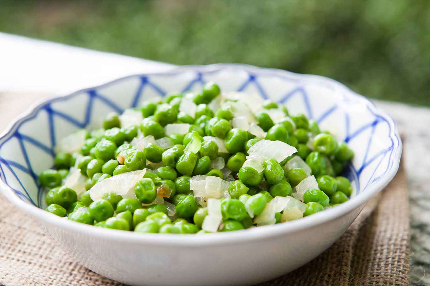peas and onion in a blue and white bowl
