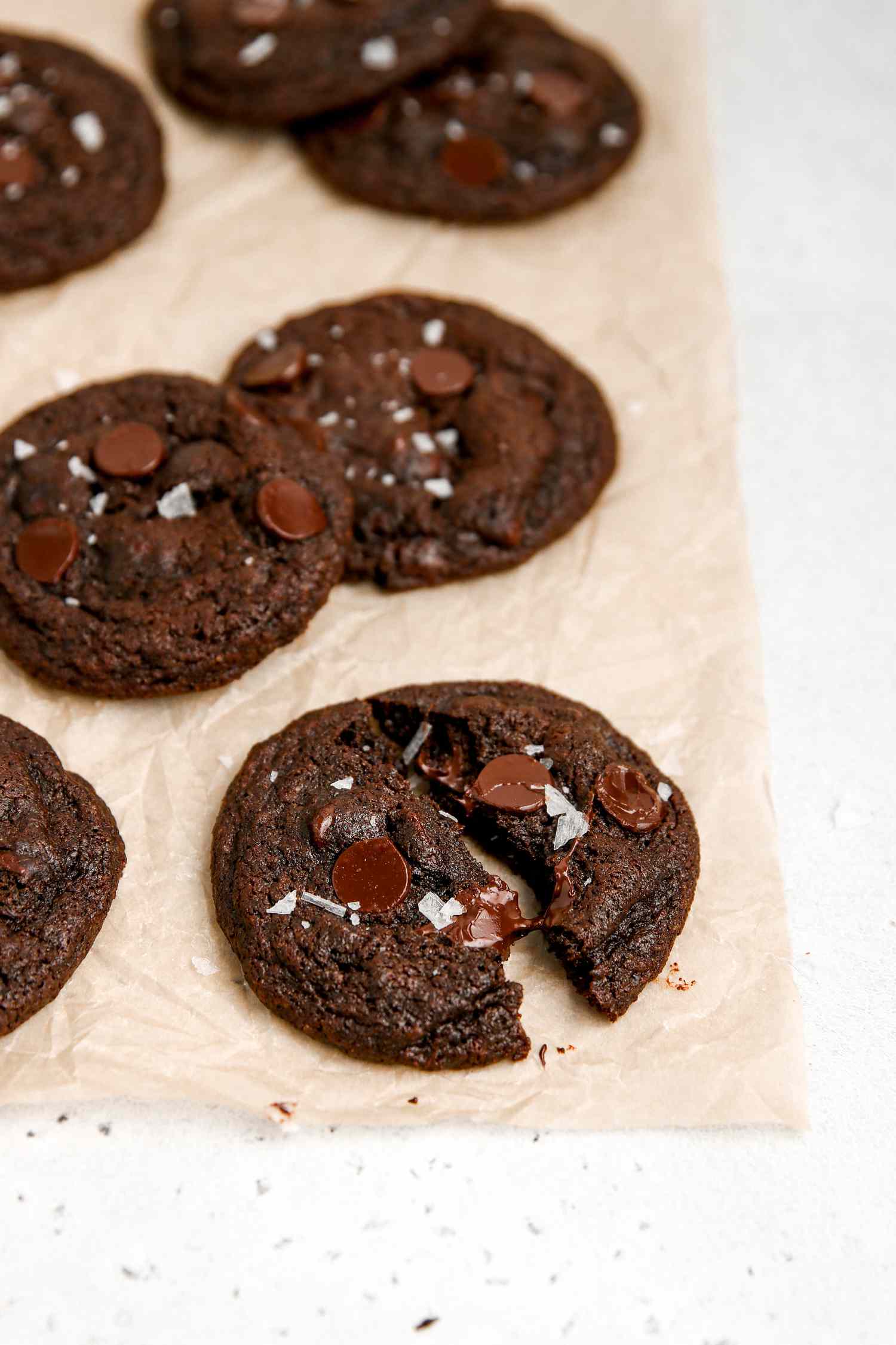 A baking sheet with chocolate chip chocolate cookies on it.