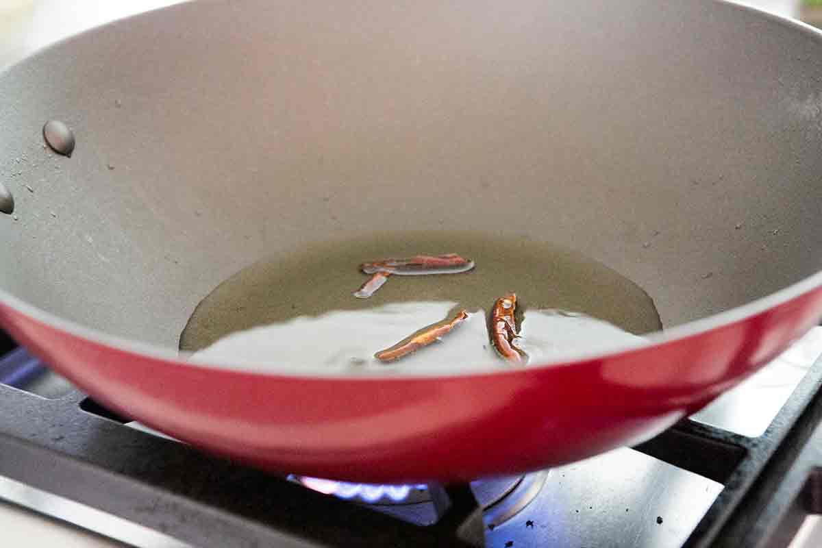cook chilies in hot oil to make the base for stir frying japanese eggplant