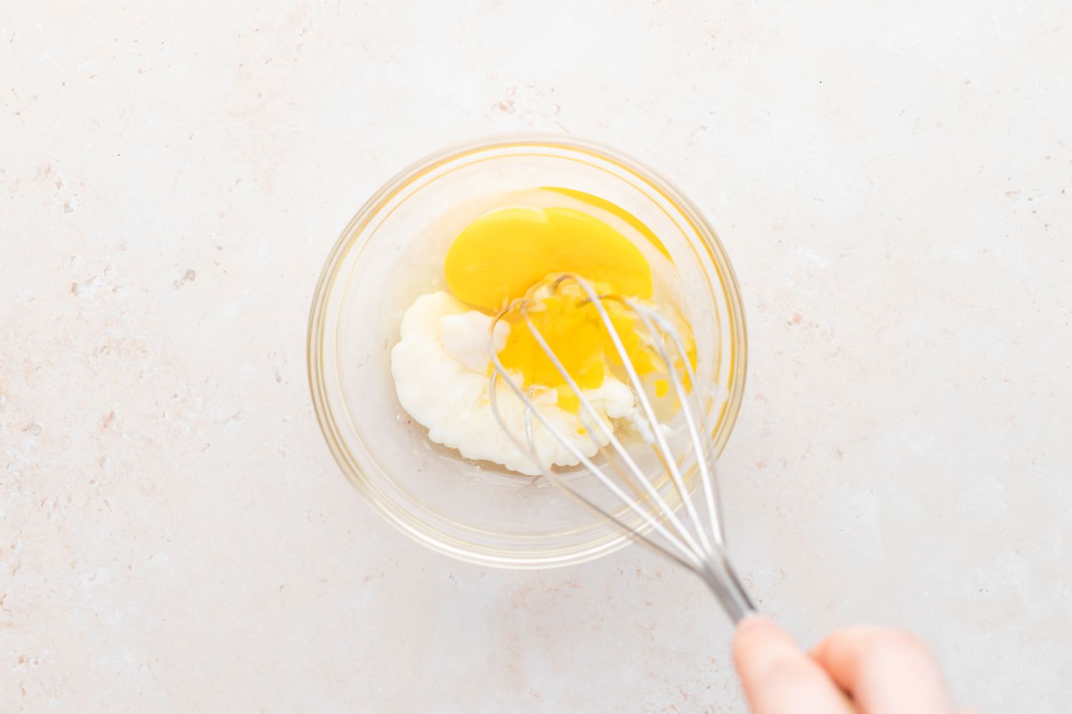 Tempering eggs to make tapioca pudding recipe.