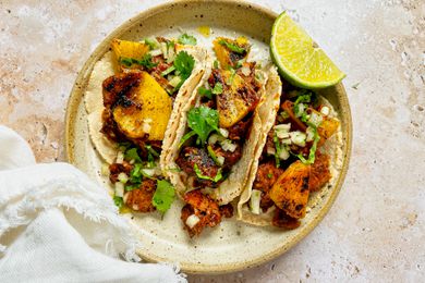 Plate of Tacos al Pastor with Pork, Pineapple, Cilantro, and a Lime Wedge 