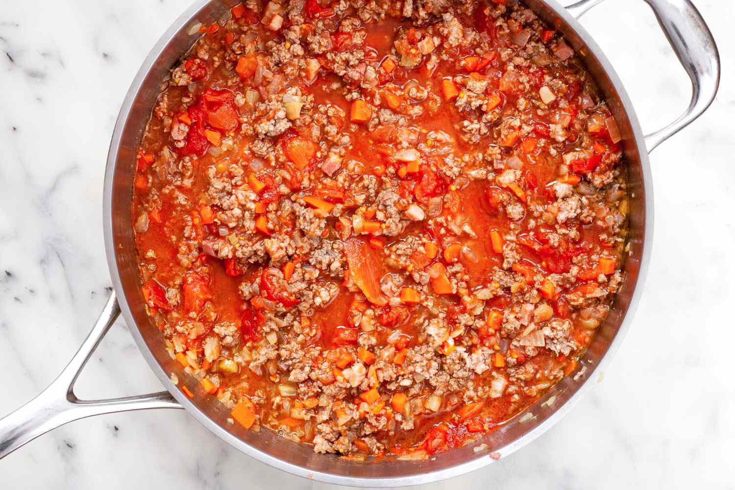 Bolognese sauce cooking in a skillet.