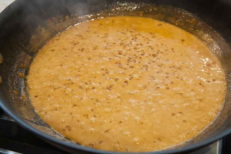 A broth mixture simmering and thinking in a wok