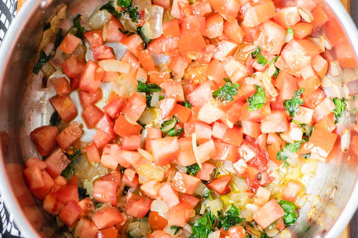 Sauteeing ingredients to make a seafood stew recipe.