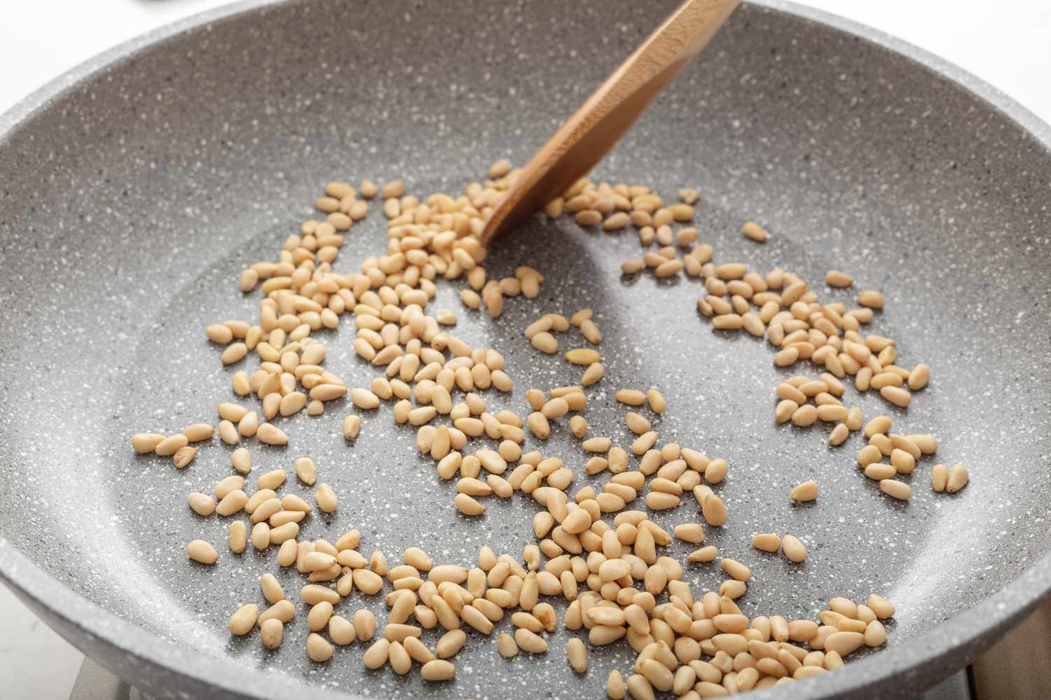 Toasting pine nuts for a cold pasta recipes.