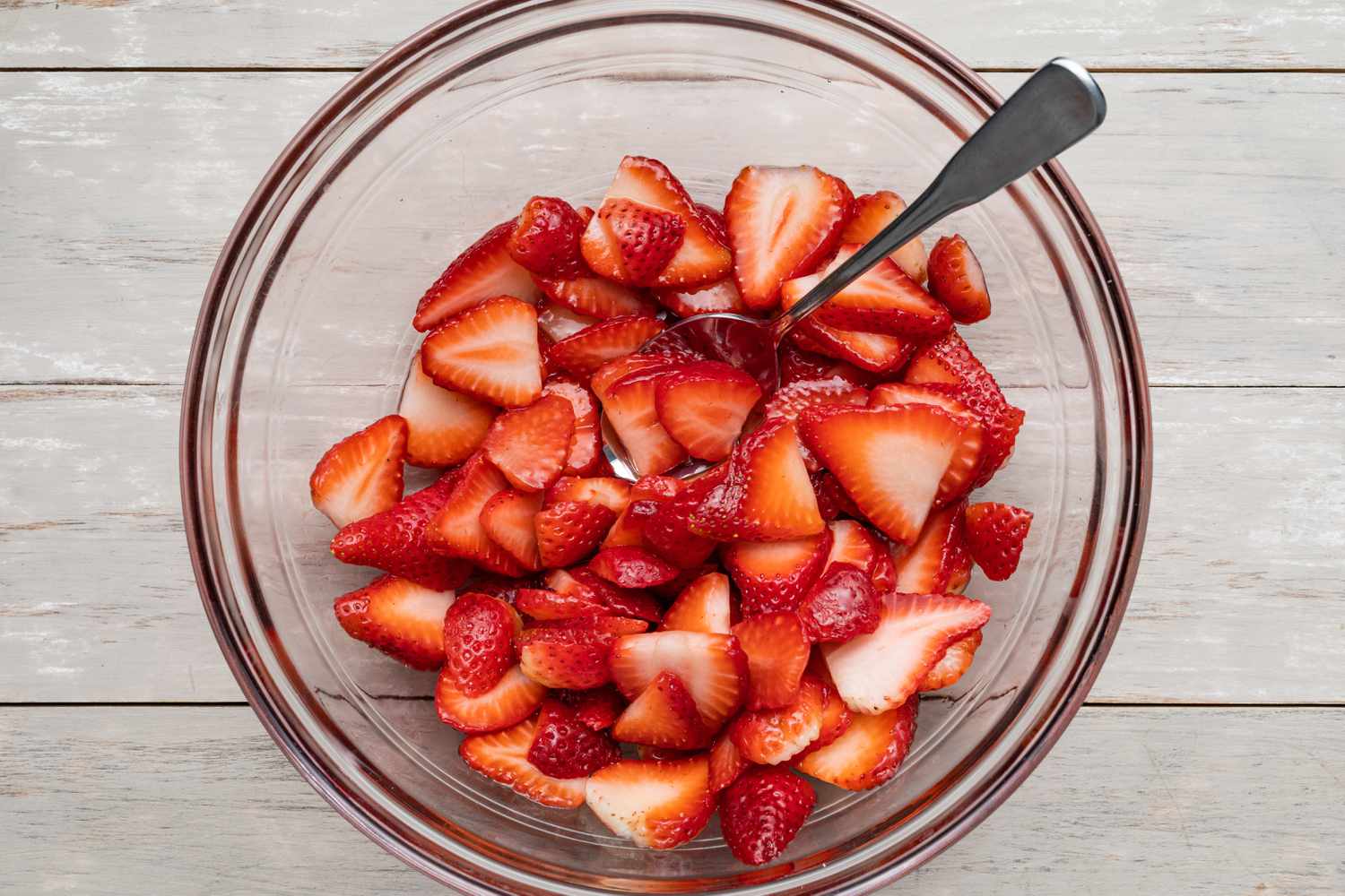 Sliced Strawberries in a Bowl With a Spoon