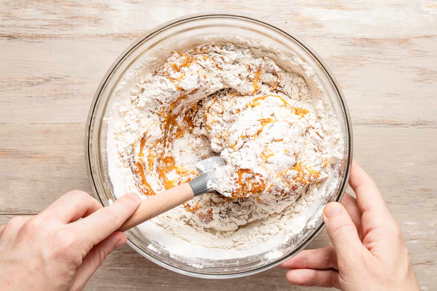Using a rubber spatula, the dry and wet ingredients are folded into each other for pumpkin spice snickerdoodle cookie recipe