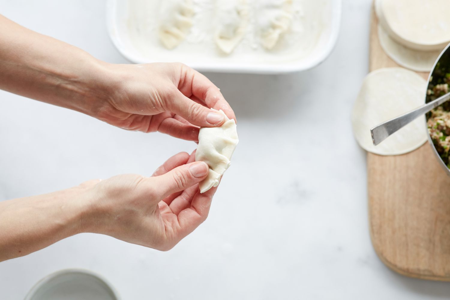 Filling and folding Korean pork and chives dumplings 
