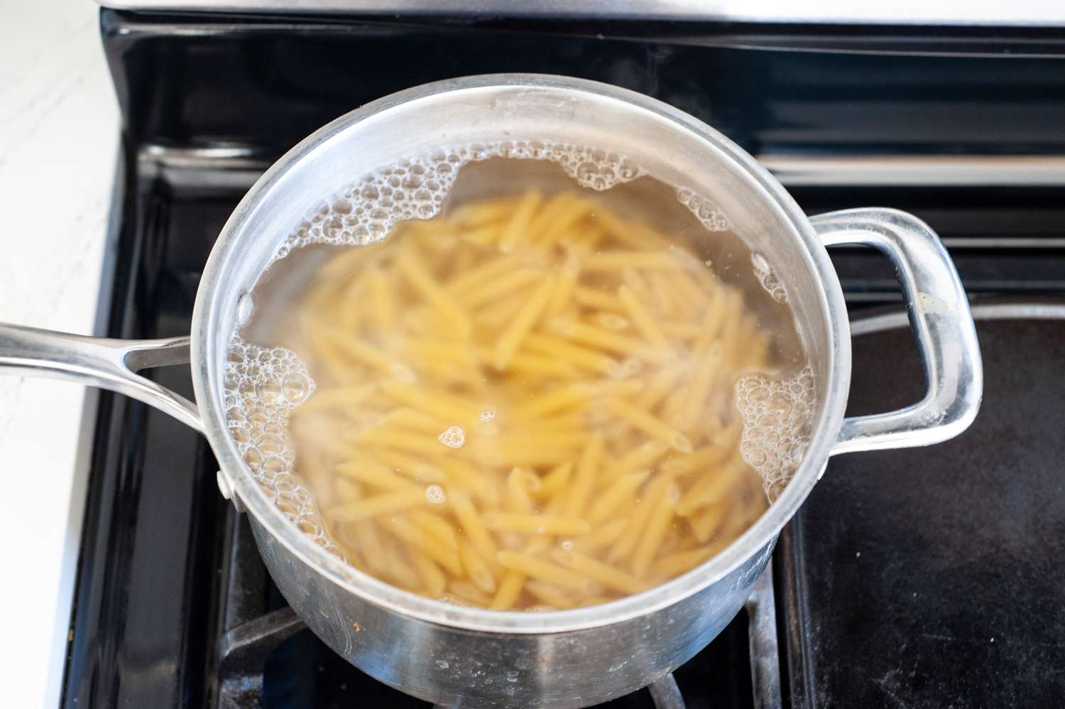 Pasta Boiling in a Pot of Water on Stove for Penne alla Vodka Recipe
