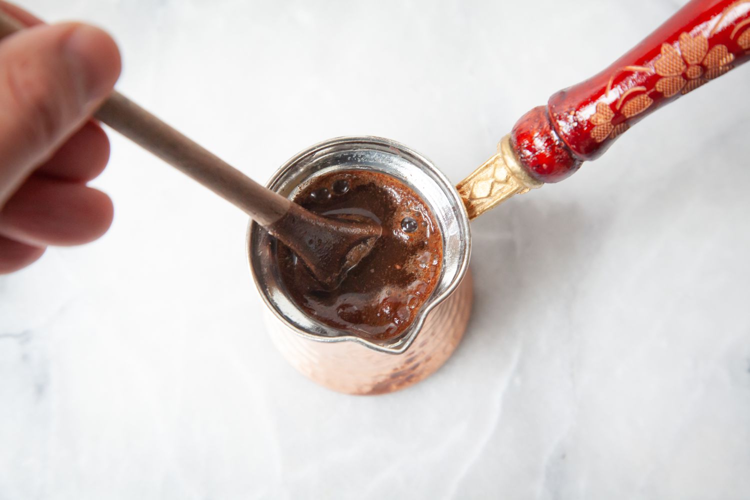 Coffee Grounds and Water Mixed Together Using a Wooden Spoon for Traditional Turkish Coffee Recipe