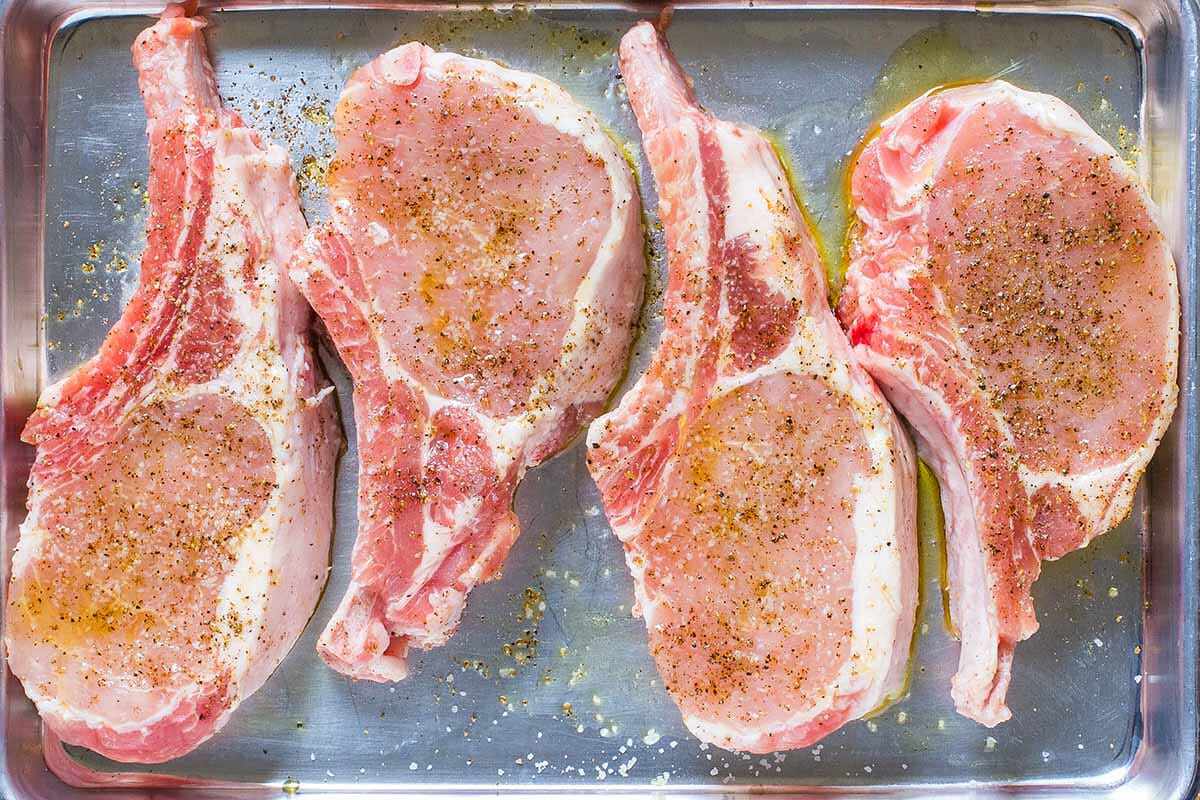 Pork loin chops on a pan with seasoning
