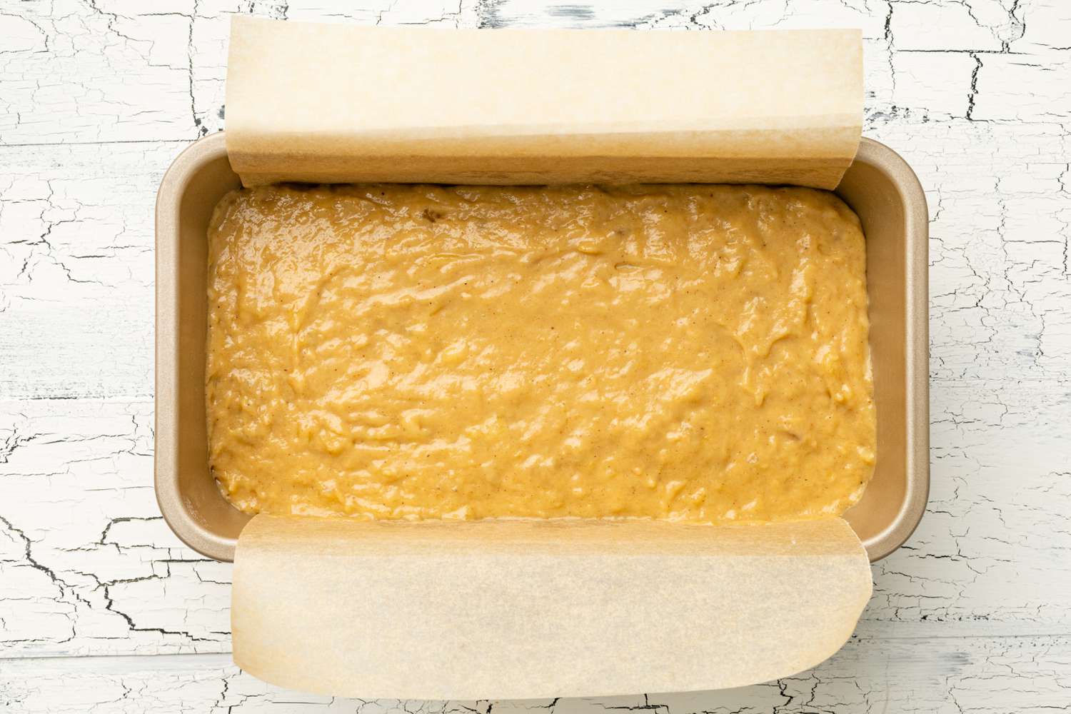 Dark and Stormy Banana Bread Batter Added to Parchment Paper Lined Loaf Pan