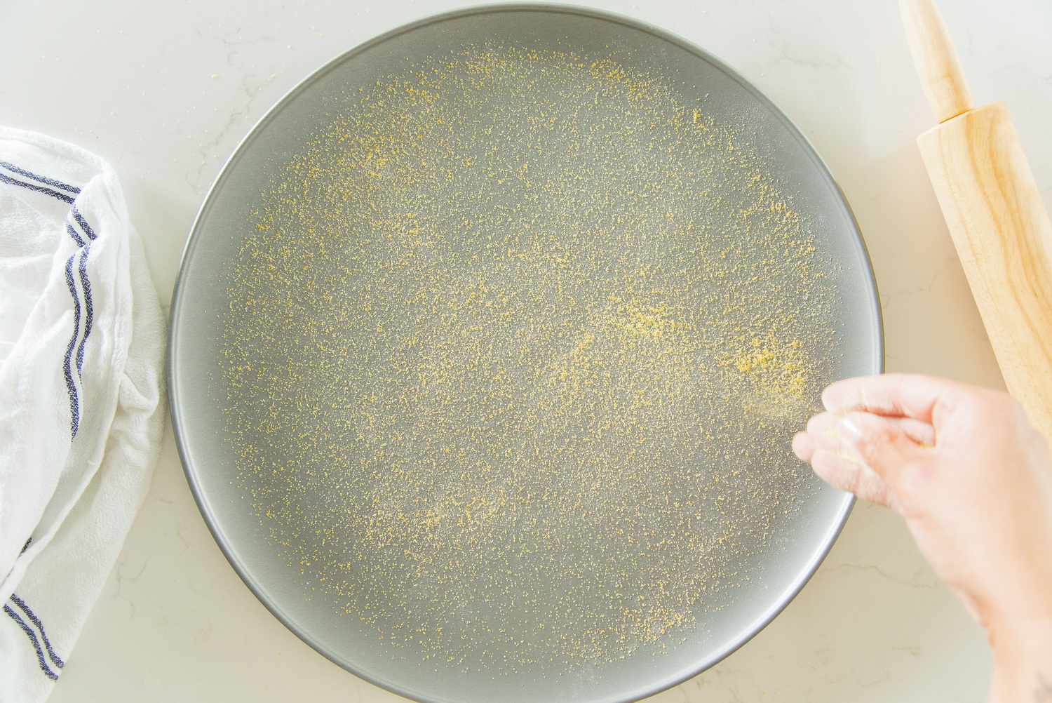 Cornmeal Sprinkled onto a Pizza Pan 