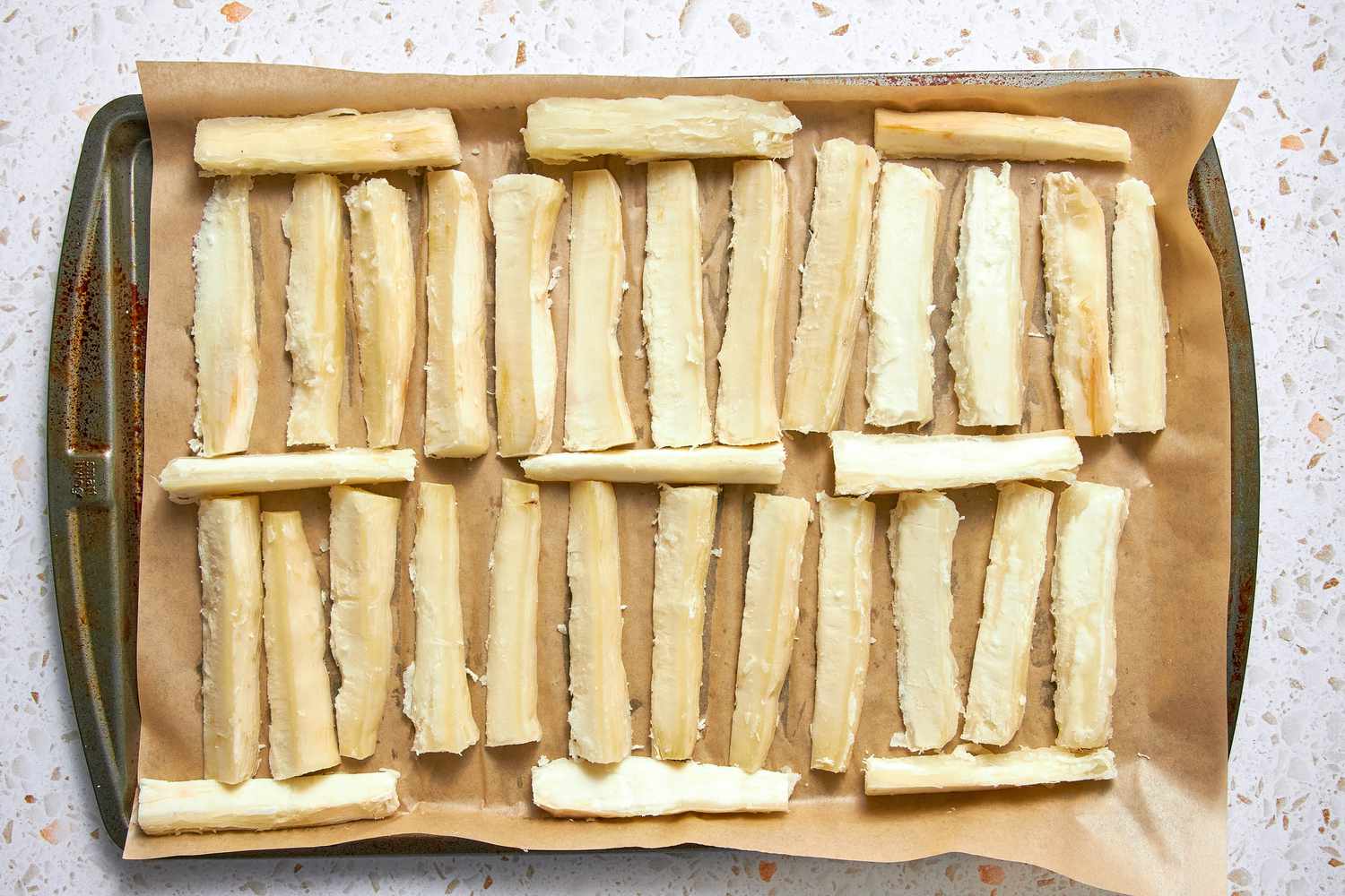 Yuca Root Wedges on a Parchment Paper Lined Baking Tray