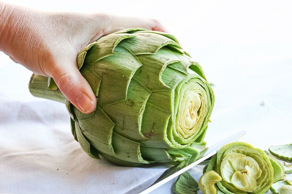 Slicing off the top of the artichoke before steaming using a serrated bread knife