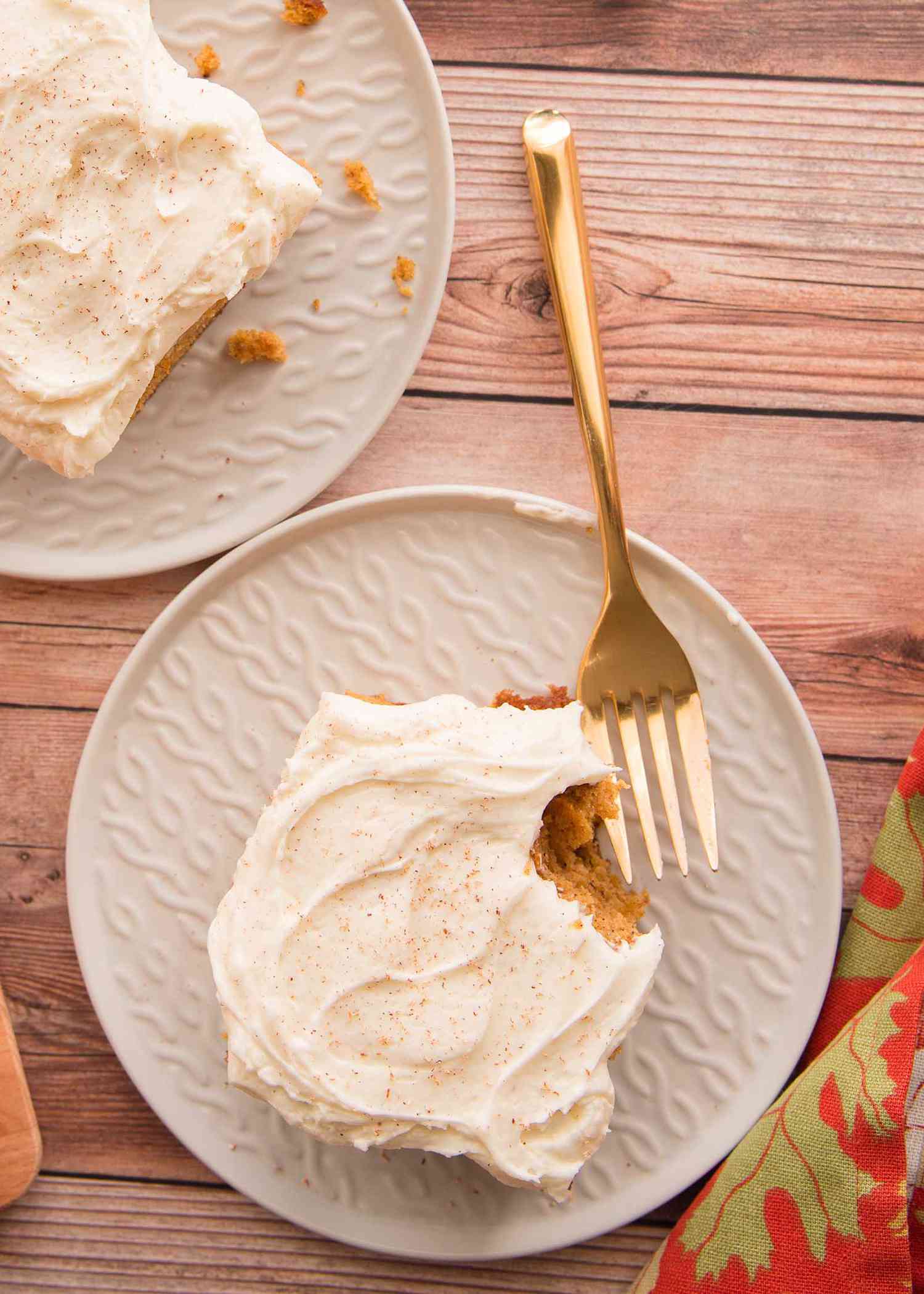 A square of The Best Pumpkin Cake with Cream Cheese Frosting on plates..