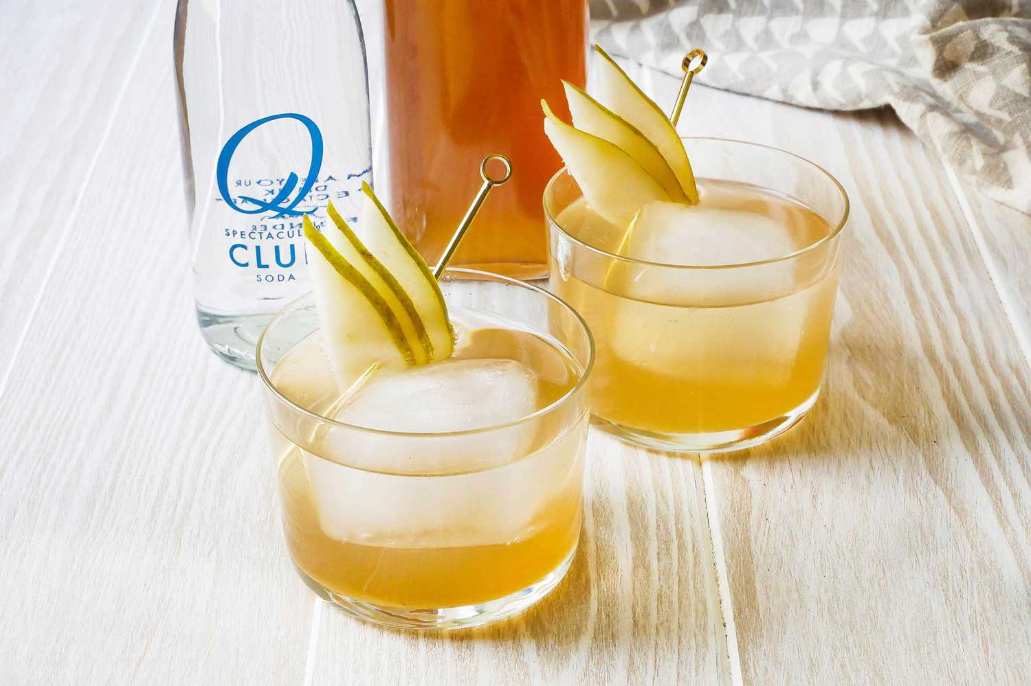 pear ginger shrub mocktail in rocks glasses garnished with pear slices