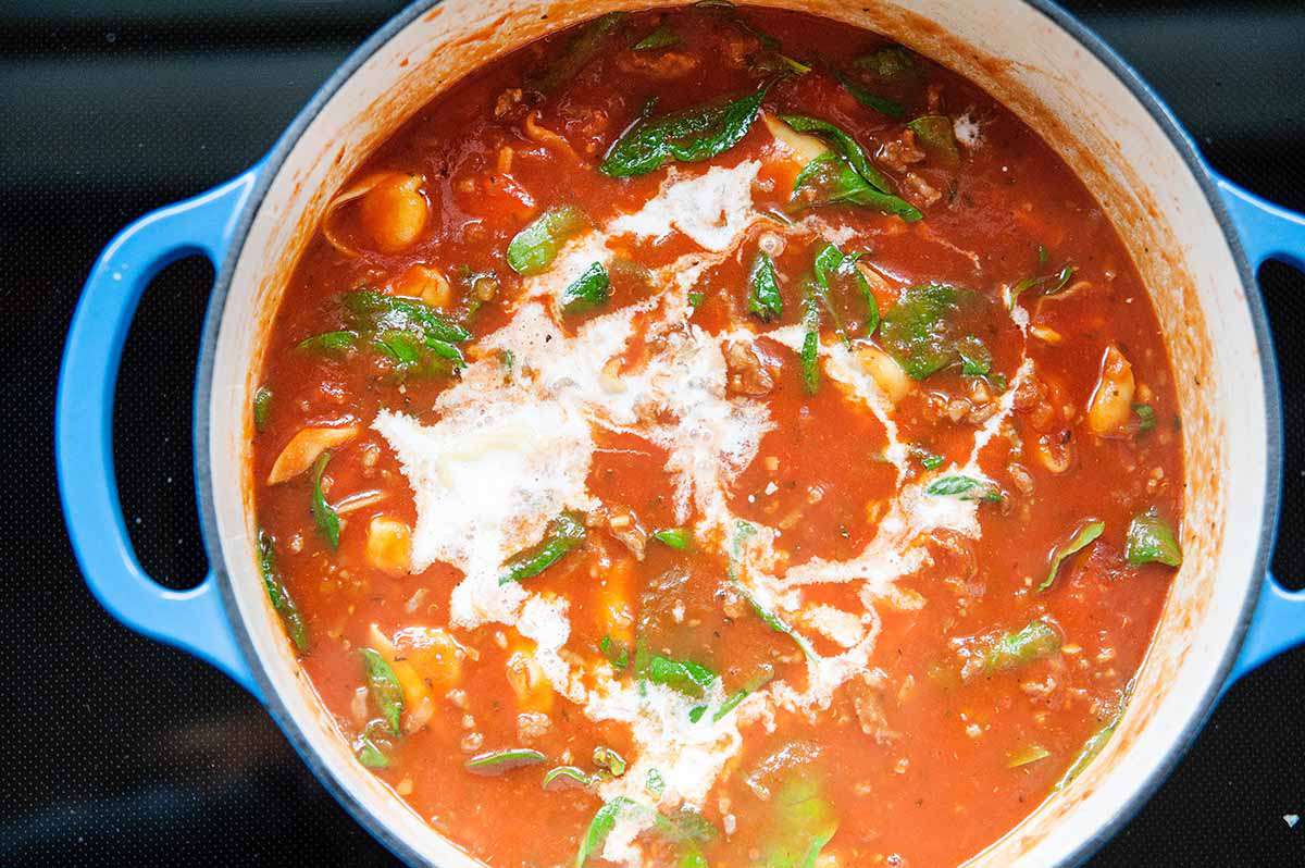 Tomato Basil Tortellini Soup - shot of tortellini soup in pot with spinach with cream