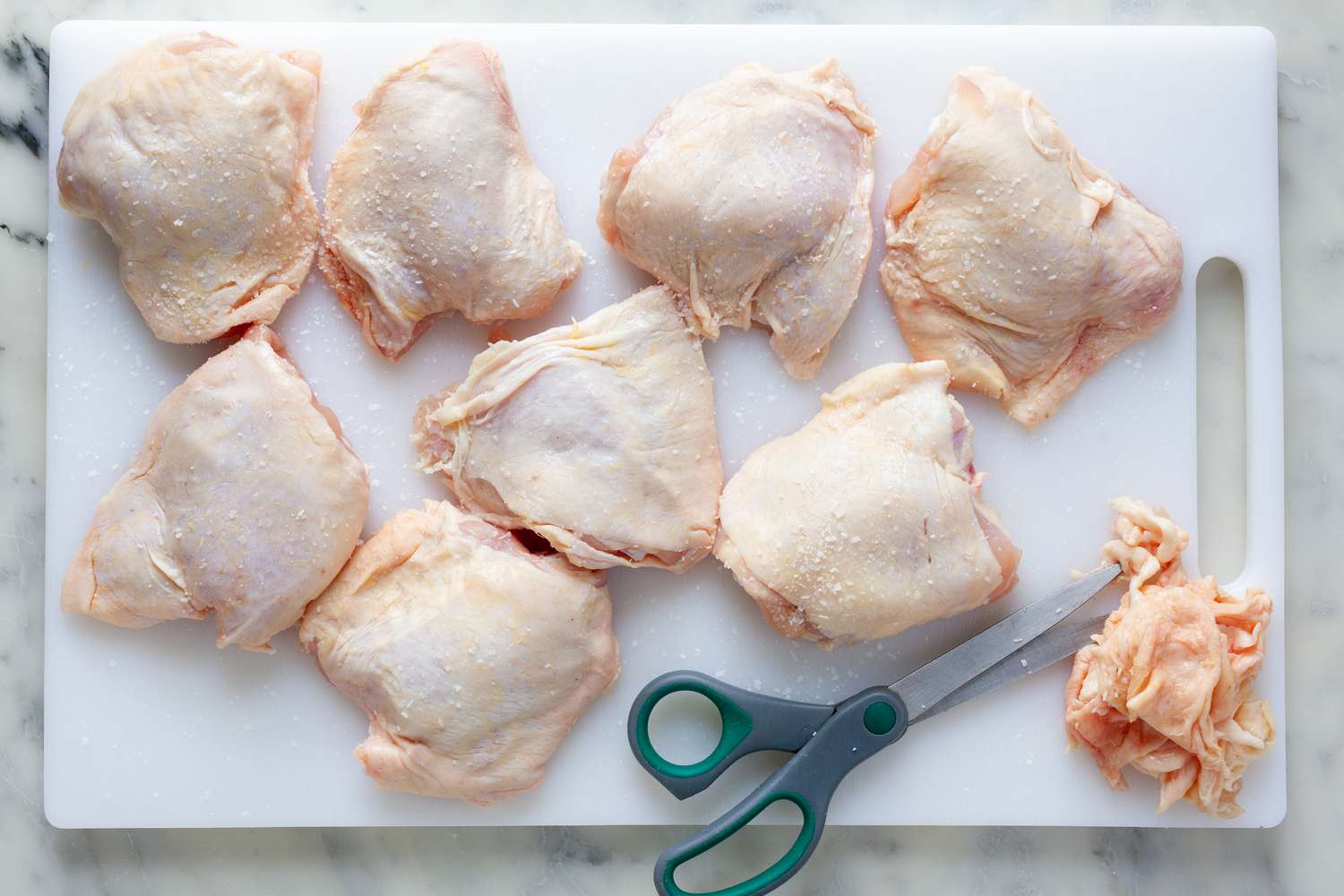 Trim chicken thighs with scissors.